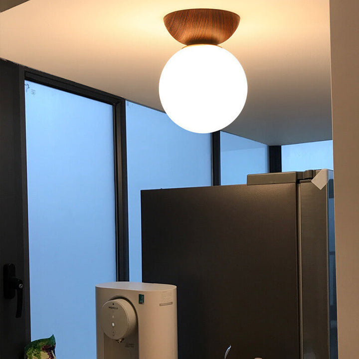 Ceiling light with glass globe and wood look in Japanese-Nordic style