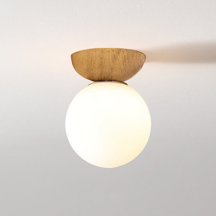 Ceiling light with glass globe and wood look in Japanese-Nordic style