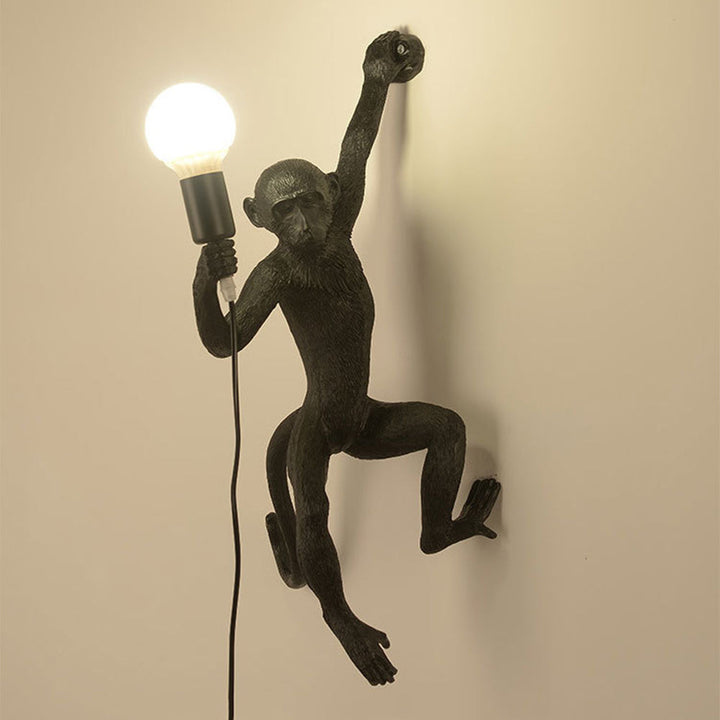 Wall lamp with playful monkey motif made of resin