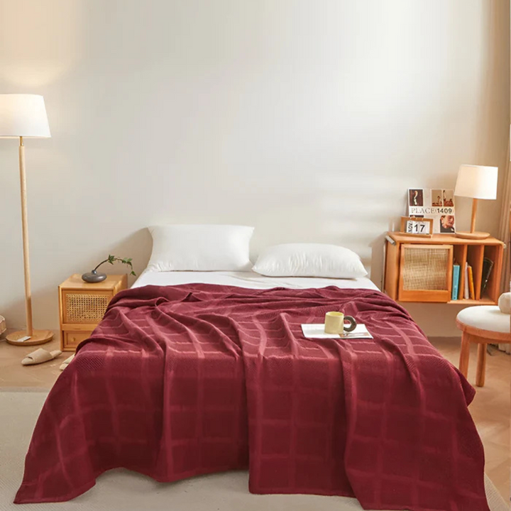 Wohndecke mit Waffelstruktur dekorativ auf einem Bett im Schlafzimmer