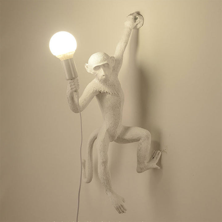 Wall lamp with playful monkey motif made of resin