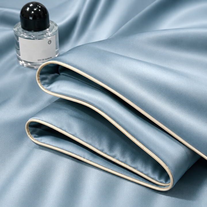 Sommerdecke aus glattem Material auf Bettwäsche im minimalistischen Schlafzimmer