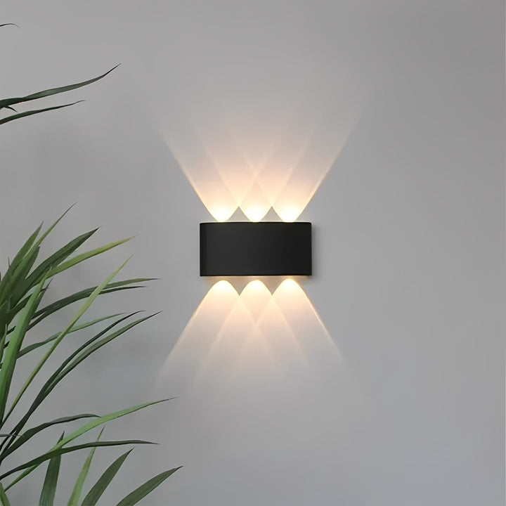 Schwarze LED-Wandleuchte mit warmweißem Licht an einer Innenwand
