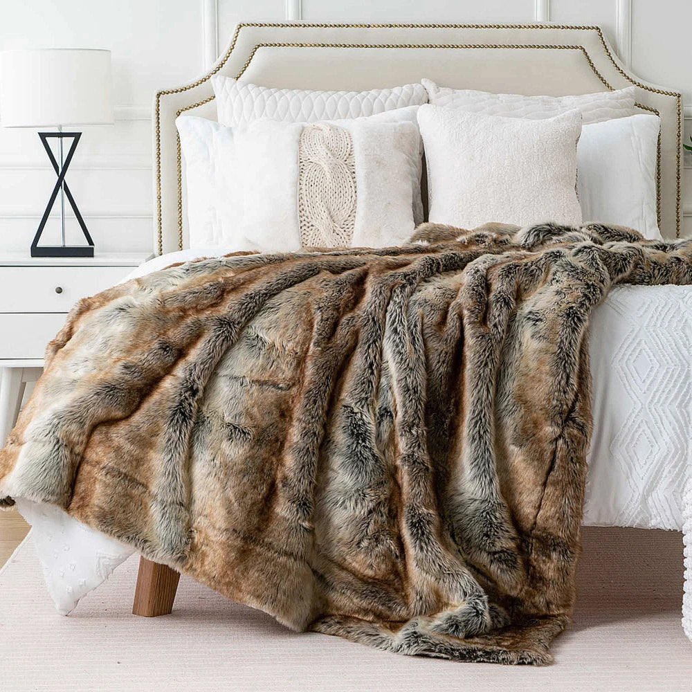 Gemütliche Kuscheldecke aus Kunstfell auf einem Bett ausgelegt