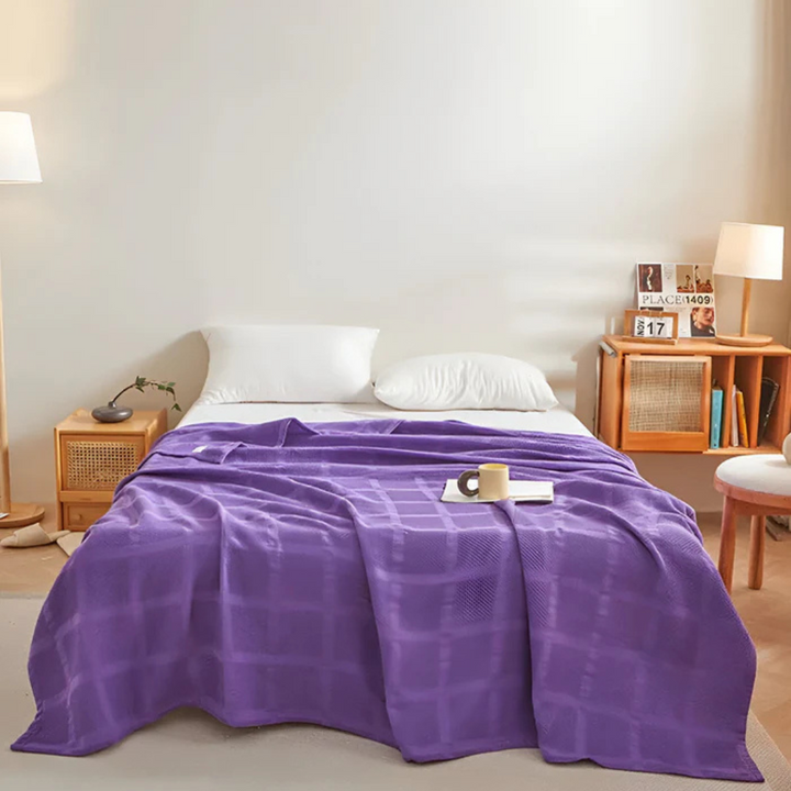 Große Wohndecke aus Baumwolle elegant über einer Couch ausgebreitet