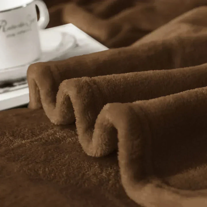 Microplüschdecke teilweise gefaltet und weich auf einem Sofa liegend