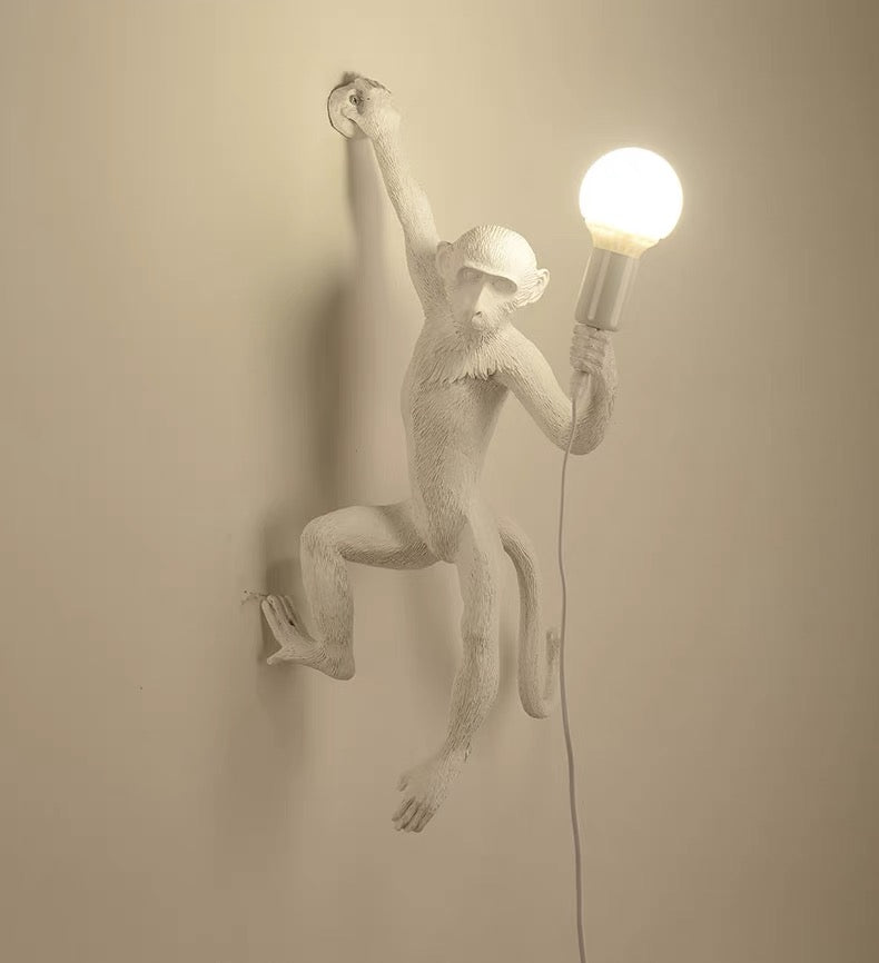 Wall lamp with playful monkey motif made of resin