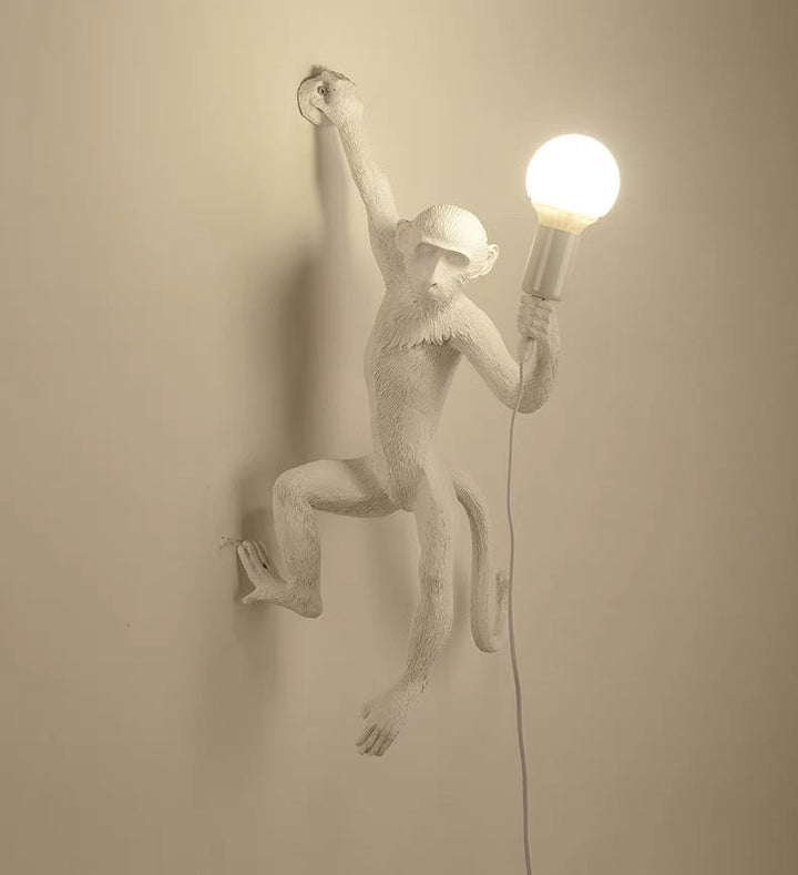 Wall lamp with playful monkey motif made of resin