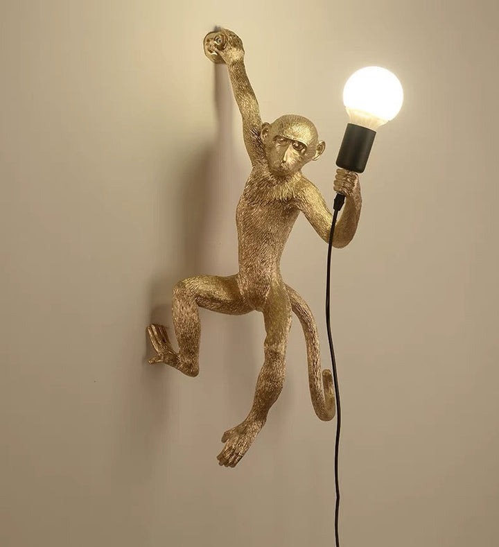 Wall lamp with playful monkey motif made of resin
