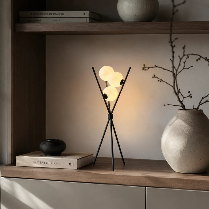 Seitenansicht der Tischlampe mit opalem Kugelschirm und drei Beinen