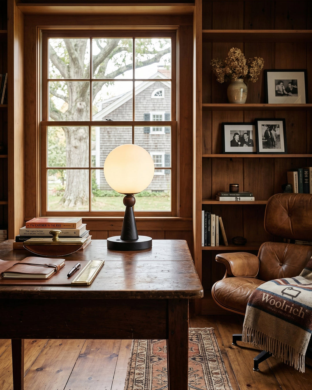 Schlichte Tischlampe mit Holzsockel und rundem Glasschirm im Interior-Look