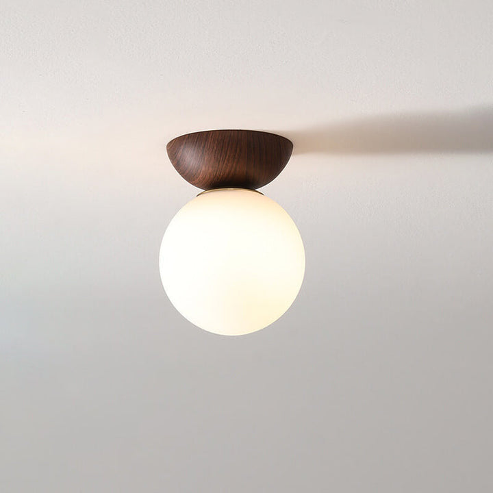 Ceiling light with glass globe and wood look in Japanese-Nordic style