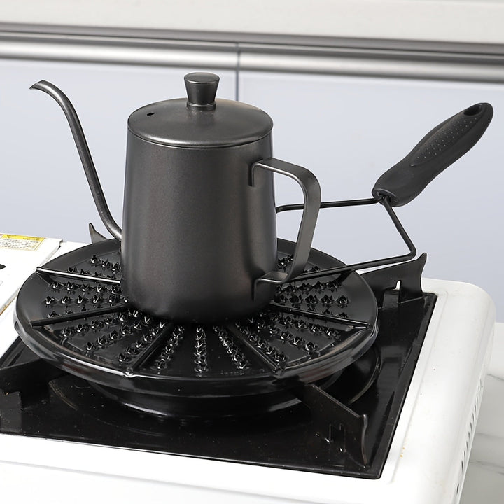 Black cast iron heat distribution pad for even cooking on a gas stove