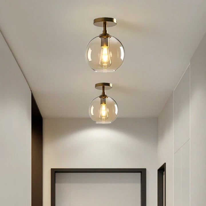 Modern ceiling light with clear glass shade and brass details