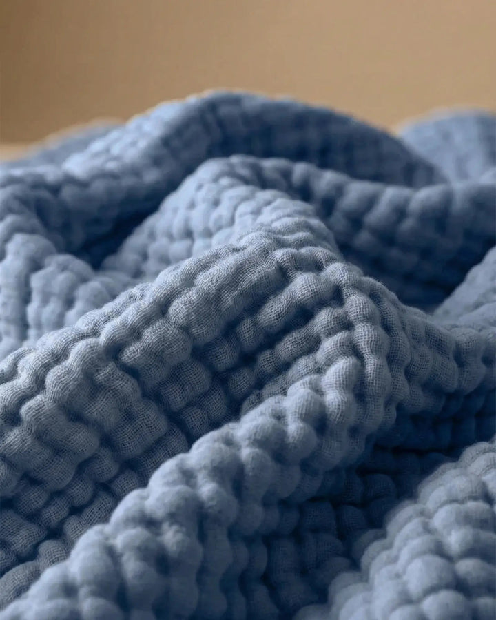 Gemütliche Musselin-Wohndecke in einem hellen Wohnzimmer