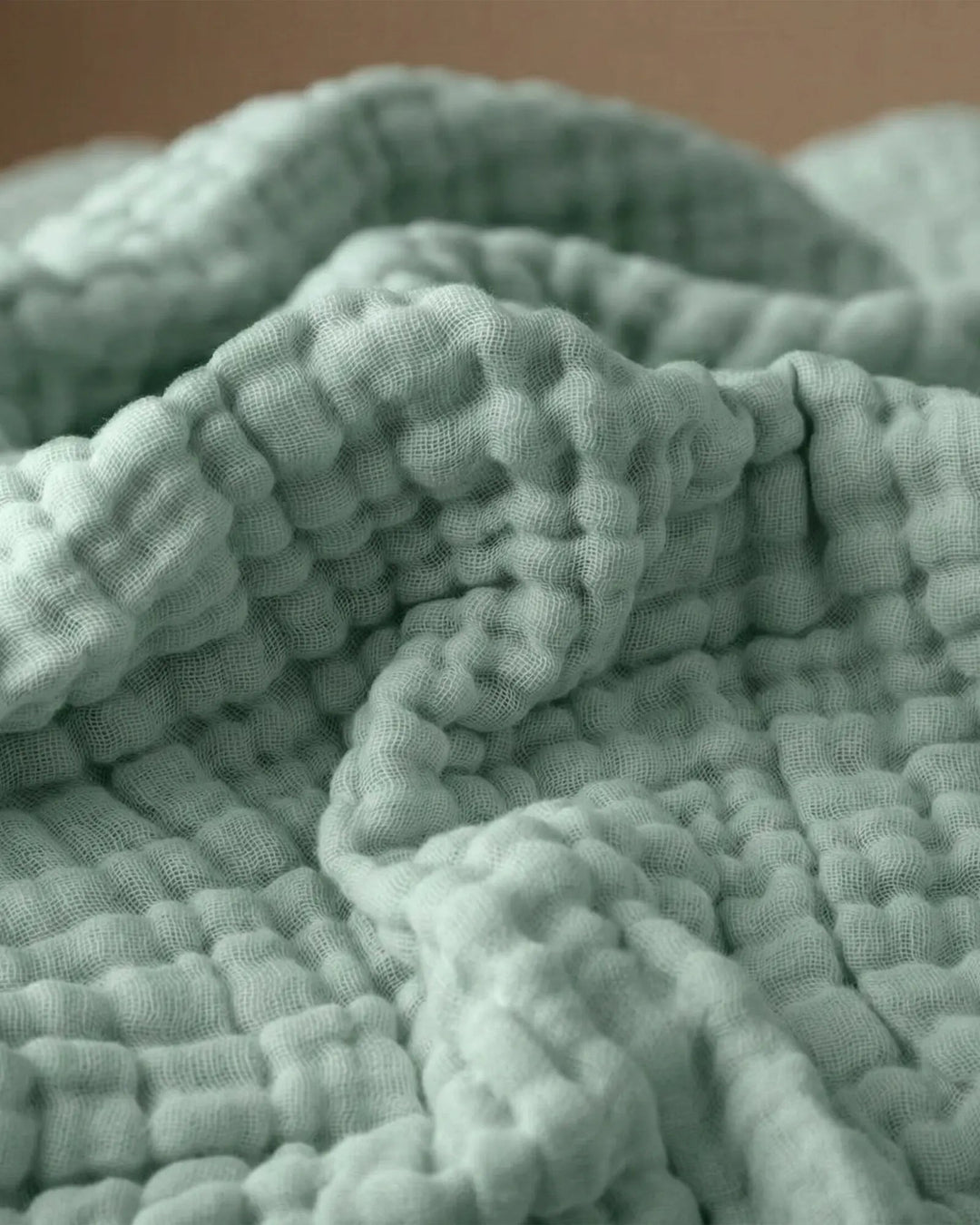 Detailansicht der feinen Musselin-Textur der Wohndecke