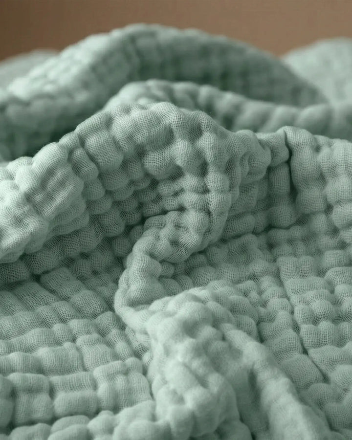 Detailansicht der feinen Musselin-Textur der Wohndecke