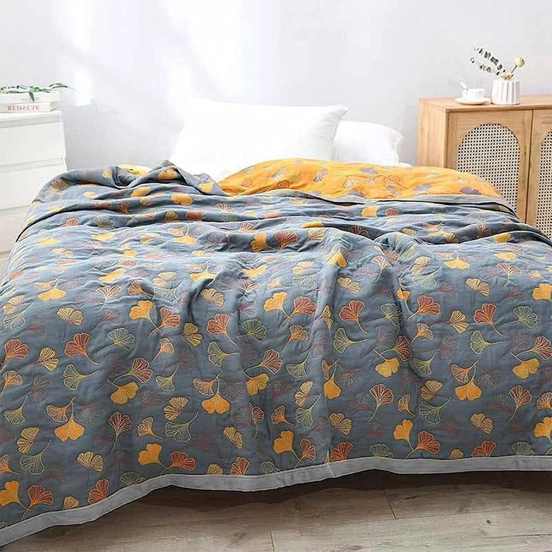 Wendbare Wohndecke mit dekorativem Ginkgoblattmuster auf einem Sofa